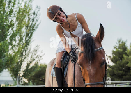 Portrait of happy woman riding on horse Banque D'Images