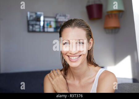 Portrait of laughing femme blonde avec les cheveux mouillés à la maison Banque D'Images