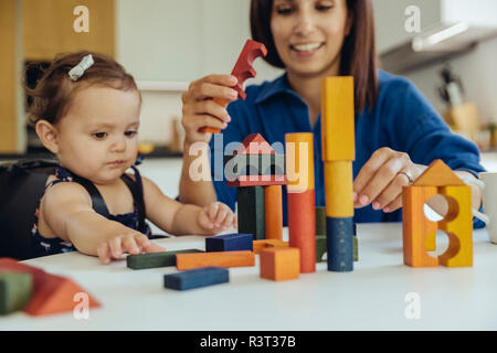 Heureuse mère et sa petite fille jouant avec des blocs de construction Banque D'Images