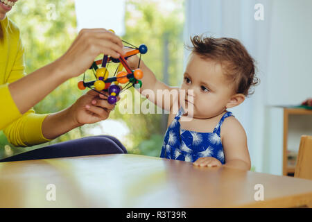 Mère et bébé fille jouer à la table à la maison Banque D'Images