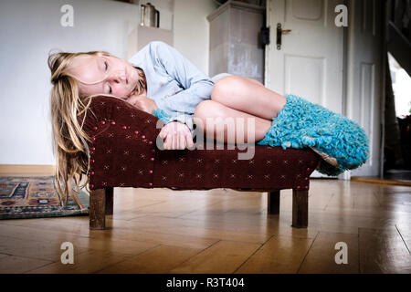 Petite fille dormir sur un petit canapé vintage Banque D'Images