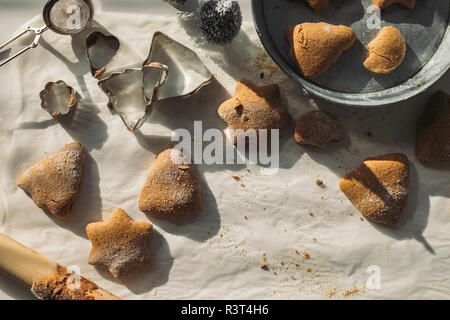 Les biscuits de Noël et d'un emporte-pièce sur du papier sulfurisé Banque D'Images