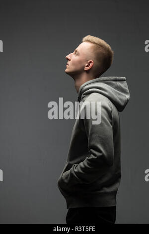 Profil de blonde young man wearing Hooded Jacket gris Banque D'Images