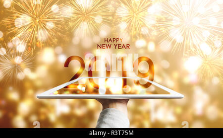 Bonne année 2019, Part holding digital tablet avec luxury gold Bokeh background fireworks Banque D'Images