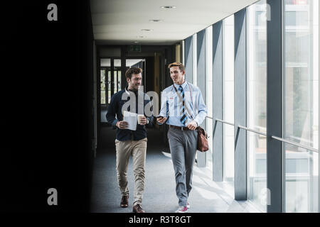Deux collègues de la marche et du langage sur l'étage Bureau Banque D'Images