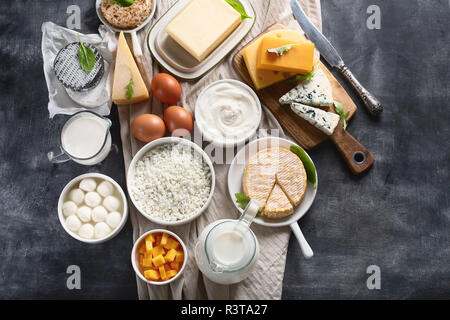 Les produits laitiers. Lait, fromage, crème sure, cottage, le yogourt et le beurre sur fond sombre. Top View with copy space Banque D'Images