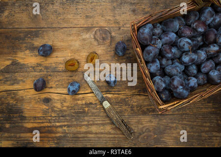 Panier en osier de prunes bio, table en bois Banque D'Images