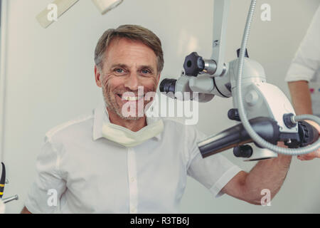 Dentiste à l'aide de microscope, portrait Banque D'Images