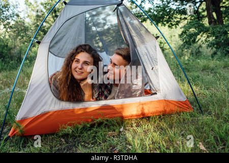 Jeune couple camper dans la nature, se trouvant dans une tente, en faisant une pause Banque D'Images