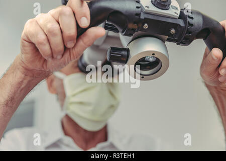 Dentiste à l'aide de microscope, portrait Banque D'Images