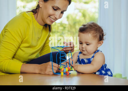 Heureuse mère et sa petite fille jouant avec boucle motrice Banque D'Images