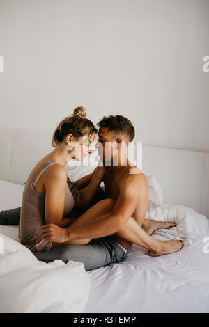 Young couple sitting on bed Banque D'Images