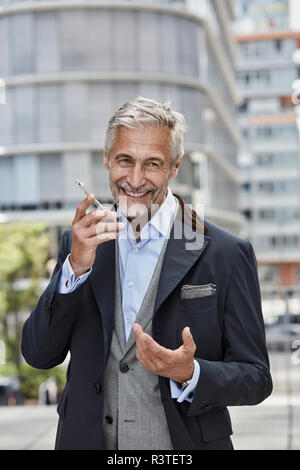 Allemagne, Düsseldorf, portrait of laughing man talking on mobile phone Banque D'Images