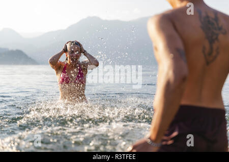 Happy young couple jouant dans un lac Banque D'Images