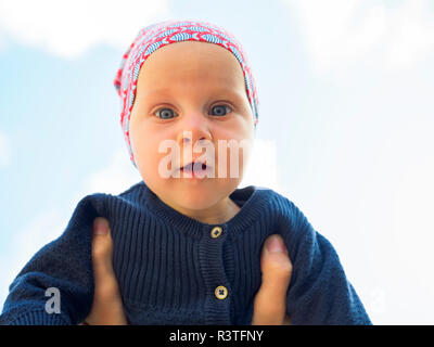 Portrait de petite fille étonnée against sky Banque D'Images