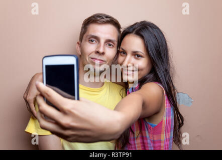 Jeune couple en tenant un téléphone mobile avec des selfies Banque D'Images