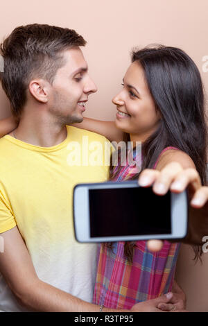 Jeune couple en tenant un téléphone mobile avec des selfies Banque D'Images