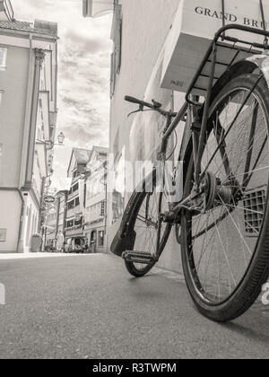 Vintage bicycle en noir et blanc transportant des caisses de vin leaning against wall Banque D'Images