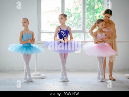 Trois petites ballerines avec un professeur de ballet dans un studio de danse Banque D'Images