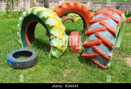 Pneus colorés / vieux pneus Roues et pneus de tracteur couleur peint voiture dans le parc de jeux pour enfants Banque D'Images