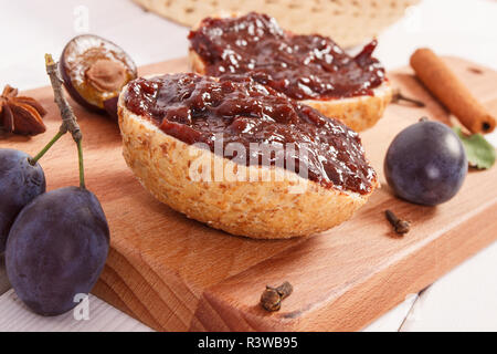 Sandwiches frais prune avec de la marmelade ou confiture sur la planche à découper en bois, concept de délicieux petit-déjeuner Banque D'Images