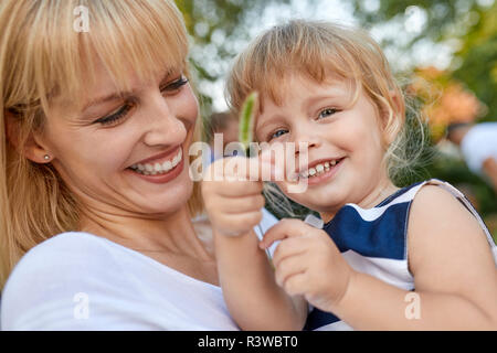 Mère heureuse avec sa fille tenant une vitre à l'extérieur Banque D'Images
