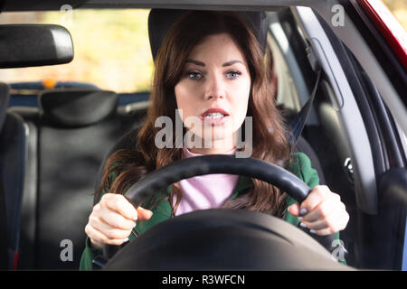 Portrait d'une jeune femme choqué Driving Car Banque D'Images