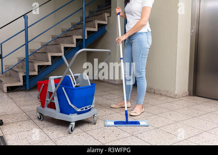 Woman Cleaning RDP dans le couloir près de l'escalier Banque D'Images