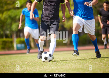 Un groupe de jeunes joueurs de football football asiatique jouant sur la cour extérieure. Banque D'Images