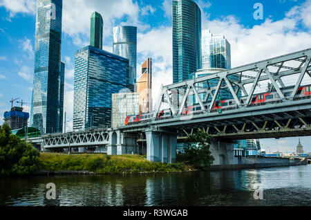 Train sur le pont de chemin de fer sur l'arrière-plan de Moscou-bâtiments de la ville, Moscou, Russie Banque D'Images