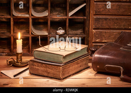 Vieux livre sur table en bois aux chandelles Banque D'Images
