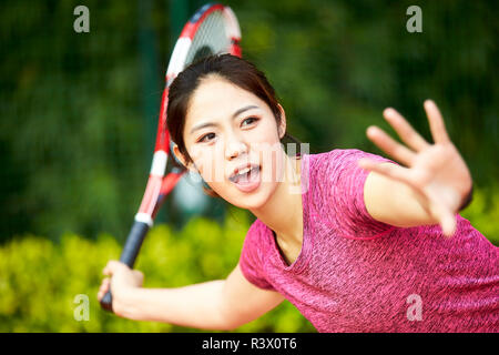 Young Asian woman tennis player hitting ball avec forehand Banque D'Images