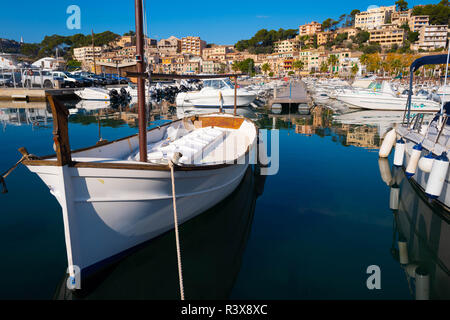 Petit bateau blanc ancré dans le port entouré par d'autres embarcations. Banque D'Images