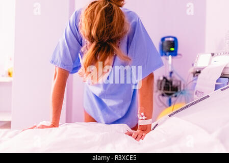 Femme malade désespérément dans la douleur dans un hôpital. Banque D'Images