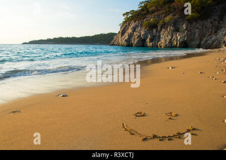 Smiley written on sandy beach Banque D'Images