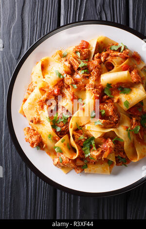 Des pâtes avec de l'épaule de porc braisée Ragu close-up sur une plaque sur le tableau noir. Haut Vertical Vue de dessus Banque D'Images