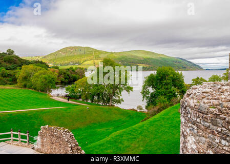 Une vue panoramique du château d'Urquhart murs avec des eaux du Loch Ness et les highlands, Ecosse faible Banque D'Images