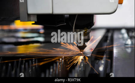 Tôle d'acier découpée au laser machine de coupe ; la lumière étincelle Banque D'Images