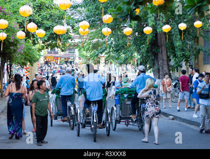 Trishaws vélos-pousse les touristes à cheval autour de l'ancienne ville de Hoi An. Banque D'Images