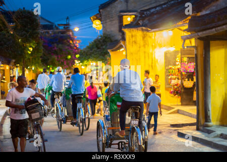 Trishaws vélos-pousse les touristes à cheval autour de l'ancienne ville de Hoi An. Banque D'Images