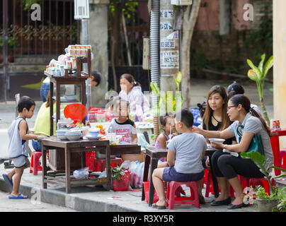 Les familles vietnamiennes ont petit-déjeuner sur le trottoir de la rue d'Hoi An, Vietnam. Banque D'Images