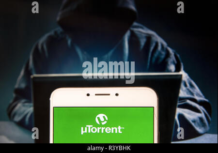 Hong Kong. 22 Nov, 2018. Logo Utorrent est vu sur un appareil mobile Android avec une figure de hacker dans l'arrière-plan. Credit : Miguel Candela/SOPA Images/ZUMA/Alamy Fil Live News Banque D'Images