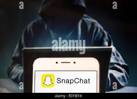 Hong Kong. 22 Nov, 2018. Application de messagerie multimédia logo SnapChat est vu sur un appareil mobile Android avec une figure de hacker dans l'arrière-plan. Credit : Miguel Candela/SOPA Images/ZUMA/Alamy Fil Live News Banque D'Images