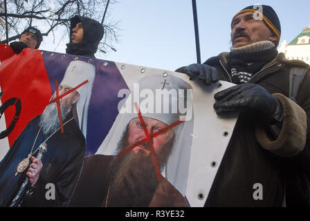 Kiev, Ukraine. 24 Nov, 2018. Les militants de l'Ukraine de l'Organisation des nationalistes ukrainiens (OUN) tenir une bannière avec visages de la Metropolitan Onufry, chef de l'Eglise orthodoxe ukrainienne du patriarcat de Moscou (L) et le Metropolitan Pavel, abbé du monastère de la Laure de Pechersk de Kiev (R) et le bandeau se lit comme suit : ''Nous allons faire un échange d'agents du FSB pour patriotes'', comme la demande des militants d'échanger les Ukrainiens emprisonnés en Russie à des prêtres de l'Église orthodoxe ukrainienne du patriarcat de Moscou au cours d'un rassemblement devant l'administration Le Président de l'Ukraine à Kiev. Le rallye de la loi Banque D'Images