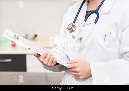 Female doctor holding patient chart presse-papiers Banque D'Images