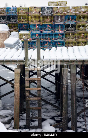 Aux Etats-Unis, dans le Maine. Les casiers à homards stockés sur un quai couvert de neige. Banque D'Images