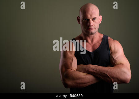 Bald man wearing tank top musclé contre l'arrière-plan de couleur Banque D'Images