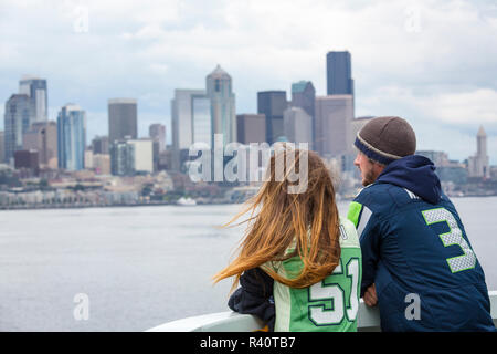 USA, l'État de Washington, Seattle. Les passagers d'un ferry près de centre-ville de Seattle, port shirts soutenant les Seattle Seahawks équipe de football. Banque D'Images