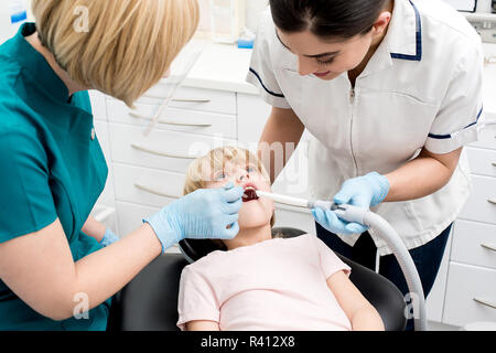 Petite fille examiné par un dentiste et son assistante Banque D'Images