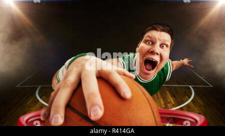 Joueur de basket-ball fou lance la balle, vue du panier. Le saut à l'athlète Banque D'Images